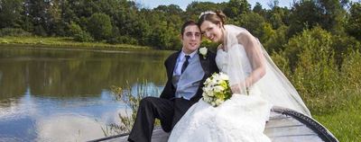 Bride and groom seated by the lake